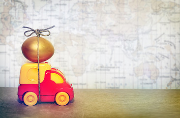 Image showing A toy truck carrying a golden egg, a symbol of the reliability of delivery of postal goods