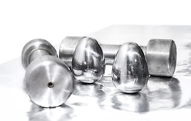 Image showing Metal dumbbells and steel eggs, the concept of sports training and the achievement of muscle strength