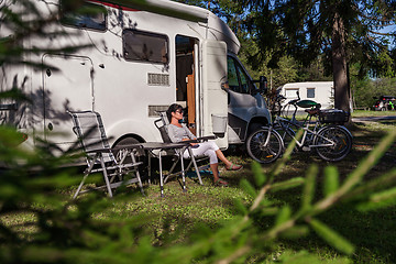 Image showing Woman resting near motorhomes in nature. Family vacation travel,