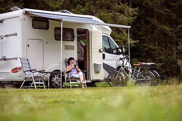 Image showing Woman is standing with a mug of coffee near the camper RV.