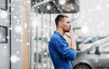 Image showing auto mechanic smoking cigarette at car workshop