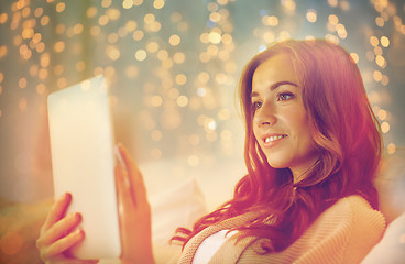 Image showing happy young woman with tablet pc in bed at home