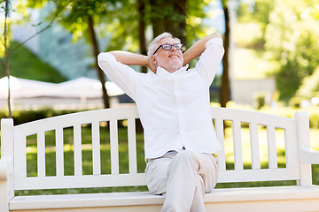 Image showing happy senior man sitting on bench at summer park