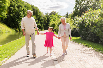 Image showing senior grandparents and granddaughter at park