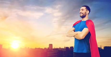 Image showing man in red superhero cape over city background