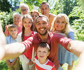 Image showing happy family taking selfie in summer garden