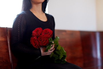 Image showing close up of woman with roses at funeral in church