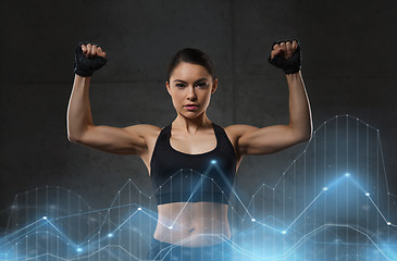 Image showing young woman flexing muscles in gym