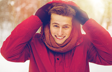 Image showing happy man in winter jacket with hood outdoors