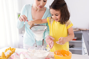 Image showing happy mother and daughter baking at home