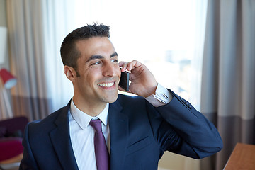 Image showing businessman calling on smartphone at hotel room