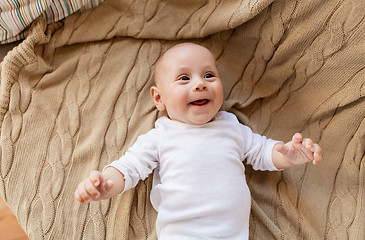 Image showing sweet little baby boy lying on knitted blanket