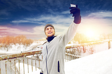 Image showing man taking selfie with smartphone in winter 