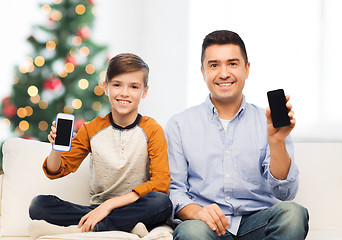 Image showing happy father and son with smartphones at christmas