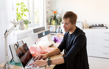 Image showing fashion designer with laptop working at studio