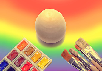 Image showing Wooden not painted egg on the background of a rainbow and a brus