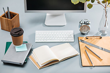 Image showing The gray desk with laptop, notepad with blank sheet, pot of flower, stylus and tablet for retouching