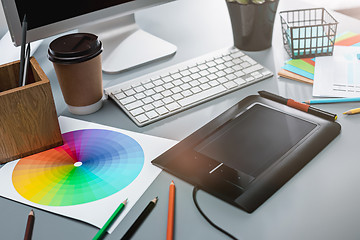 Image showing The gray desk with laptop, notepad with blank sheet, pot of flower, stylus and tablet for retouching