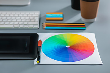 Image showing The gray desk with laptop, notepad with blank sheet, pot of flower, stylus and tablet for retouching