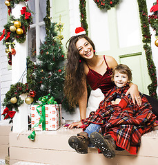 Image showing happy family on Christmas in red hats waiting gests and smiling