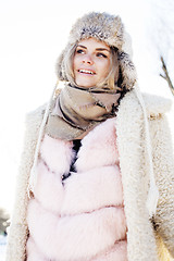 Image showing young pretty teenage hipster girl outdoor in winter snow park having fun drinking coffee, warming up happy smiling, lifestyle people concept