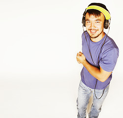 Image showing young asian man in hat and headphones listening music on white b