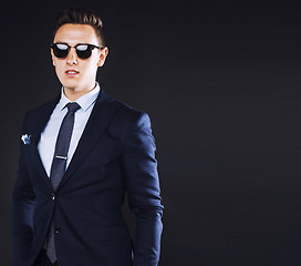 Image showing young pretty business man standing on black background, modern h