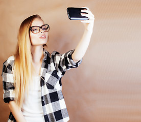 Image showing young pretty blond woman with smartphone posing smiling, making 