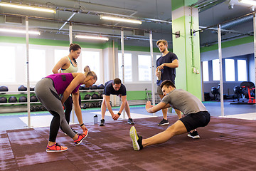 Image showing group of happy friends stretching in gym