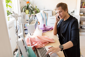 Image showing fashion designer calling on smartphone at studio