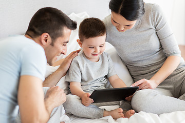 Image showing happy family with tablet pc in bed at home