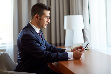 Image showing businessman with tablet pc working at hotel room