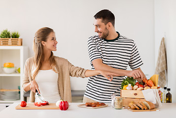 Image showing happy couple cooking food at home kitchen