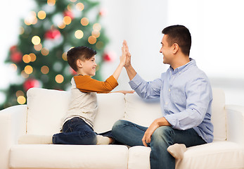 Image showing happy father and son doing high five at christmas