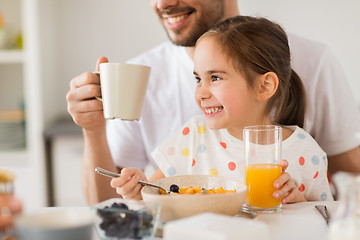 Image showing happy family drinking juice for breakfast at home