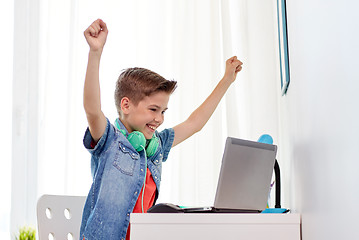 Image showing boy with headphones playing video game on laptop