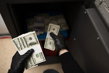 Image showing thief stealing money from safe at crime scene