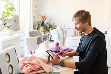 Image showing fashion designer with tablet pc working at studio