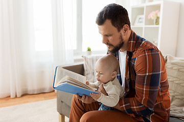 Image showing happy father and little baby boy with book at home