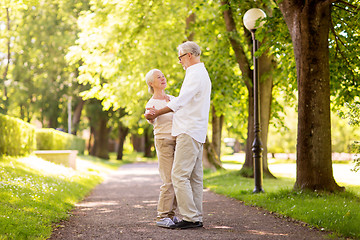 Image showing happy senior couple dancing at summer park