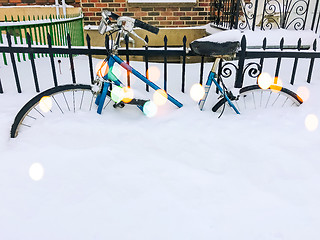 Image showing Bicycle in snow near urban building, with bokeh light effect