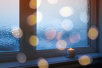 Image showing Frosted window, candle and golden bokeh lights