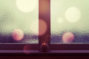 Image showing Winter window with burning candle and bokeh lights