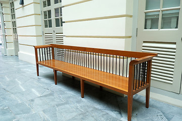 Image showing Wooden bench in front of a wall