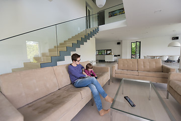 Image showing mother and her cute little daughter are using a tablet