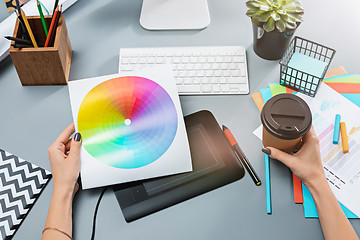 Image showing The gray desk with laptop, notepad with blank sheet, pot of flower, stylus and tablet for retouching