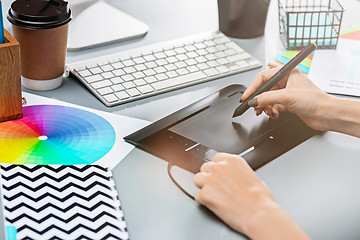 Image showing The gray desk with laptop, notepad with blank sheet, pot of flower, stylus and tablet for retouching