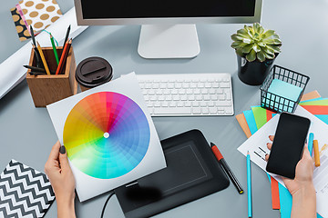 Image showing The gray desk with laptop, notepad with blank sheet, pot of flower, stylus and tablet for retouching