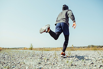 Image showing Running sport. Man runner sprinting outdoor in scenic nature. Fit muscular male athlete training trail running for marathon run.