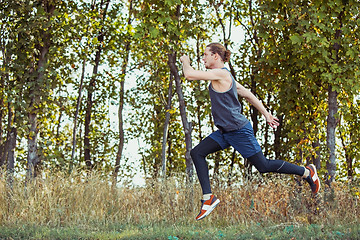 Image showing Running sport. Man runner sprinting outdoor in scenic nature. Fit muscular male athlete training trail running for marathon run.